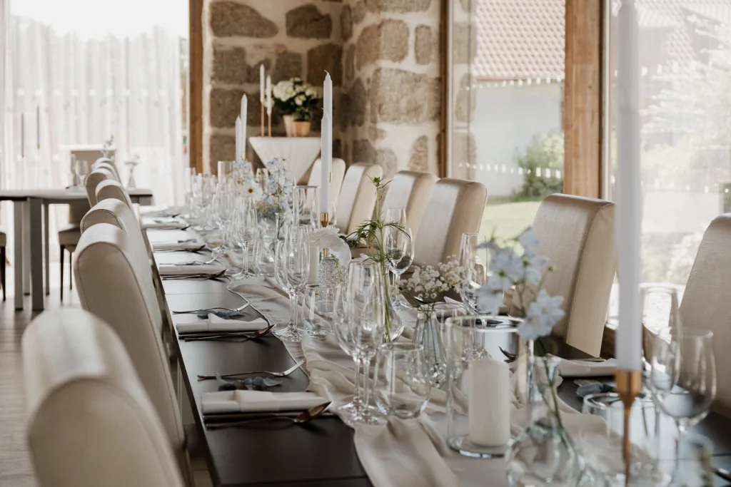 Slavnostně prostřená svatební tabule v sále Pohoda Nárameč s kamennými sloupy a výhledem do zeleně.